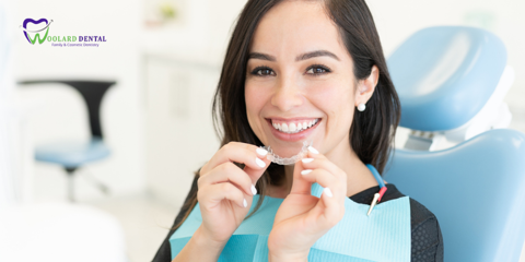 woman with clear invisalign teeth aligner at the dentist braces