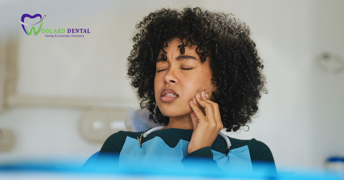 woman holding her mouth tooth in pain at the dentist